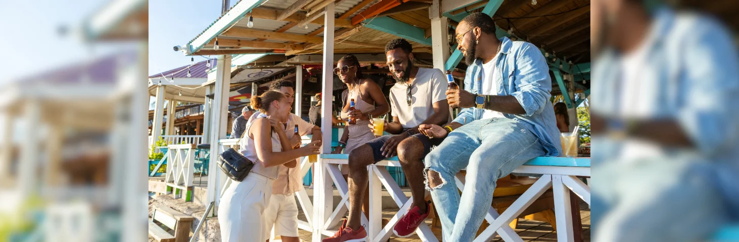 Five people sat on the fence of a bar in St Kitts.