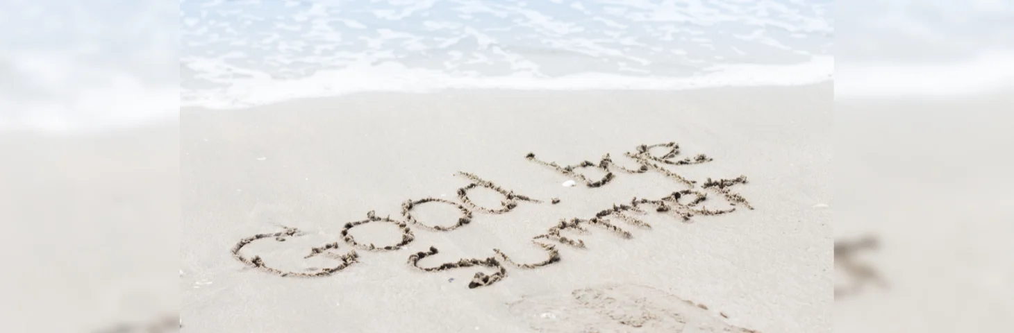 The words 'Goodbye Summer' drawn in the sand on a beach.