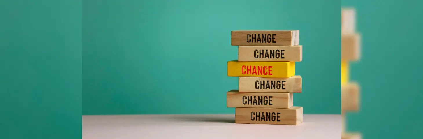 Six wooden blocks, five of which are labelled 'Change' with one yellow one in the middle labelled 'Chance'.