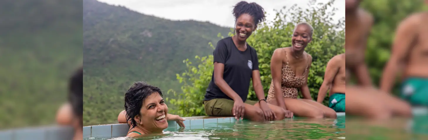 Image of travellers laughing together in a pool in Kenya. 