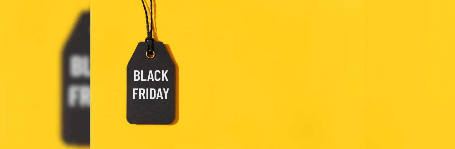 A black gift label with the words 'BLACK FRIDAY' written on it on a yellow background.